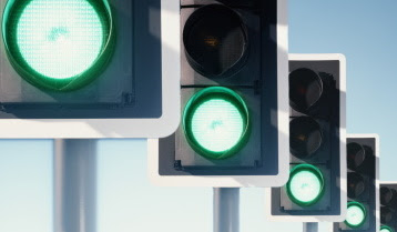 Row of traffic lights, green lights illuminated (Digital Composite)